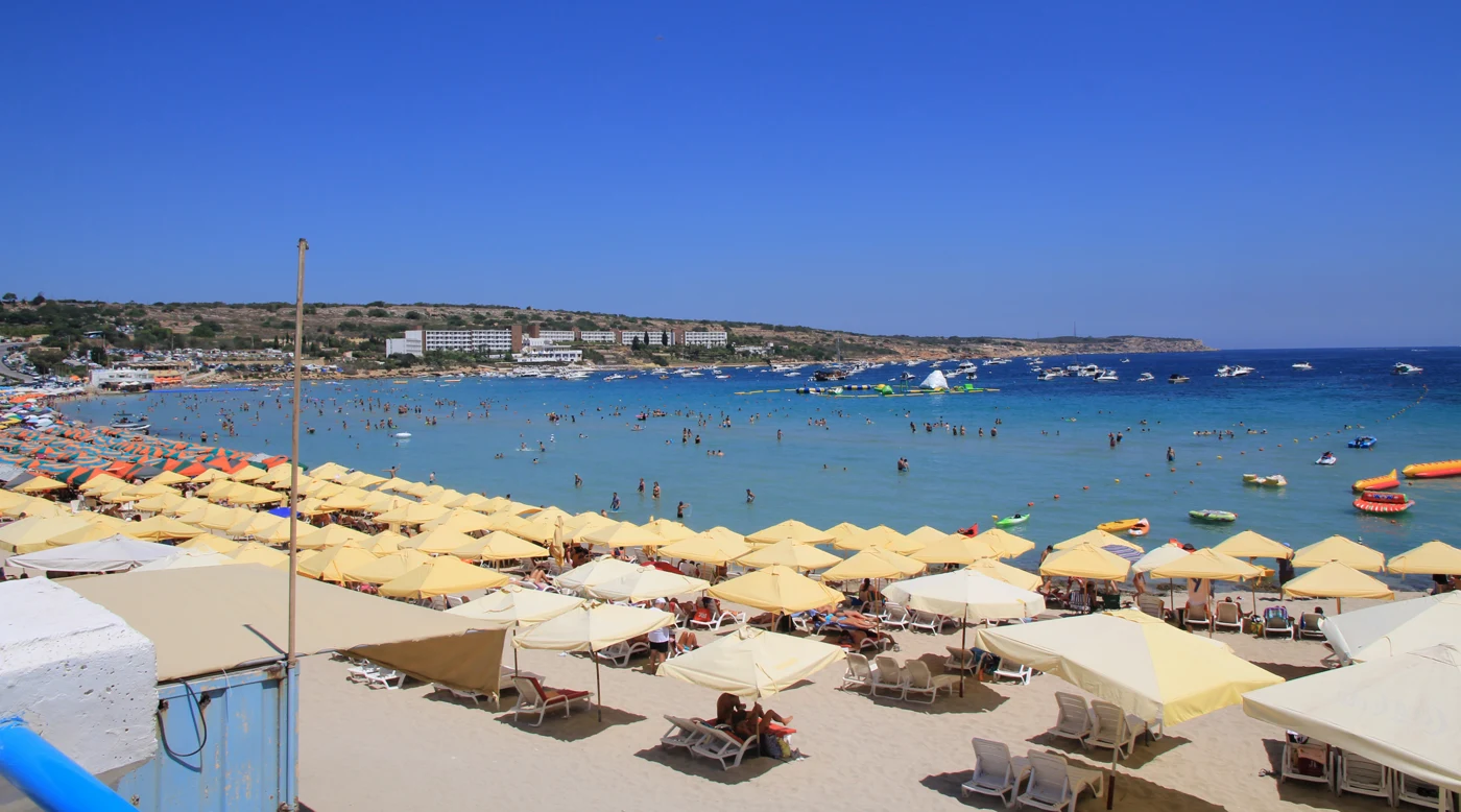 Sun umbrellas and beachgoers at Mellieħa Bay, Malta.